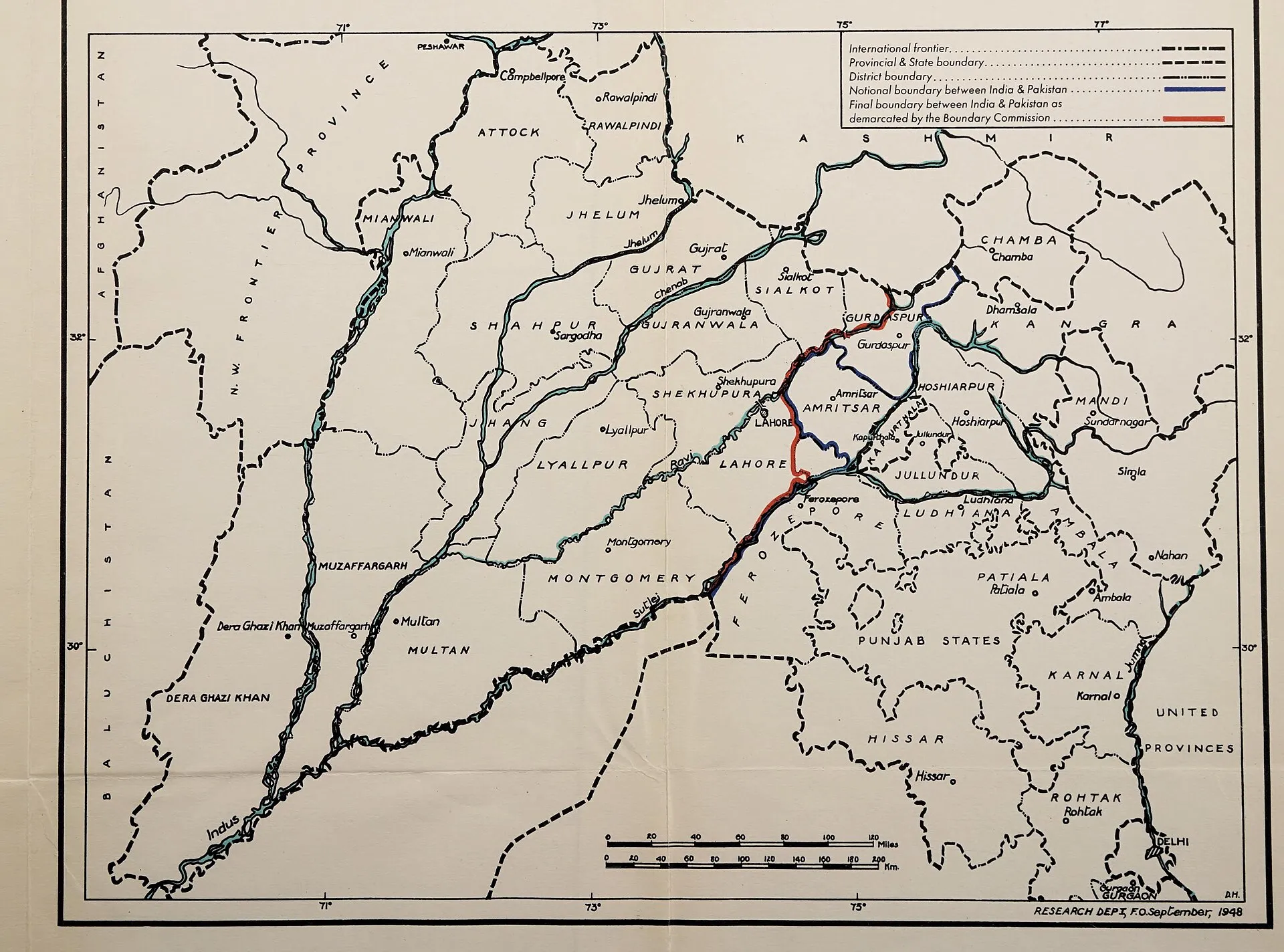 Mapa en blanc i negre del Panjab del 1948 amb els districtes i els rius, i dues línies de colors entre Lahore i Amritsar: la blava de la frontera provisional i la vermella de la frontera definitiva dibuixada per la Comissió de Límits; llegenda a dalt a la dreta i escala a baix.